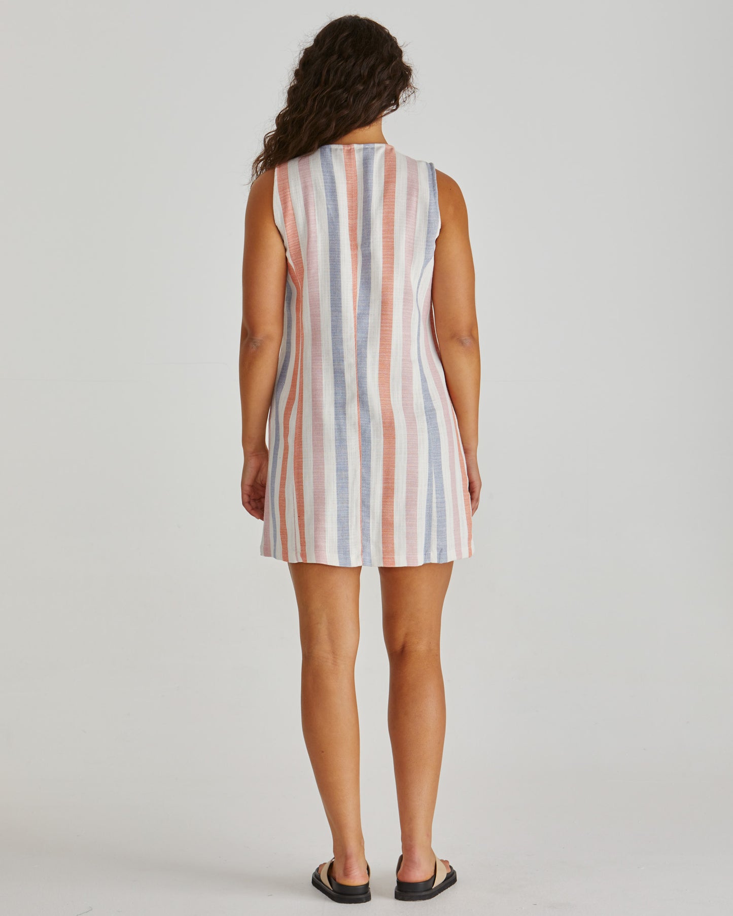 Back View of Lady wearing the SASS Travis Vest Dress in stripe with princess seam detail and side pockets. Linen combination. Available at Loloma Living, Tamborine Mountain. Stockist of SASS and Betty Basics.
