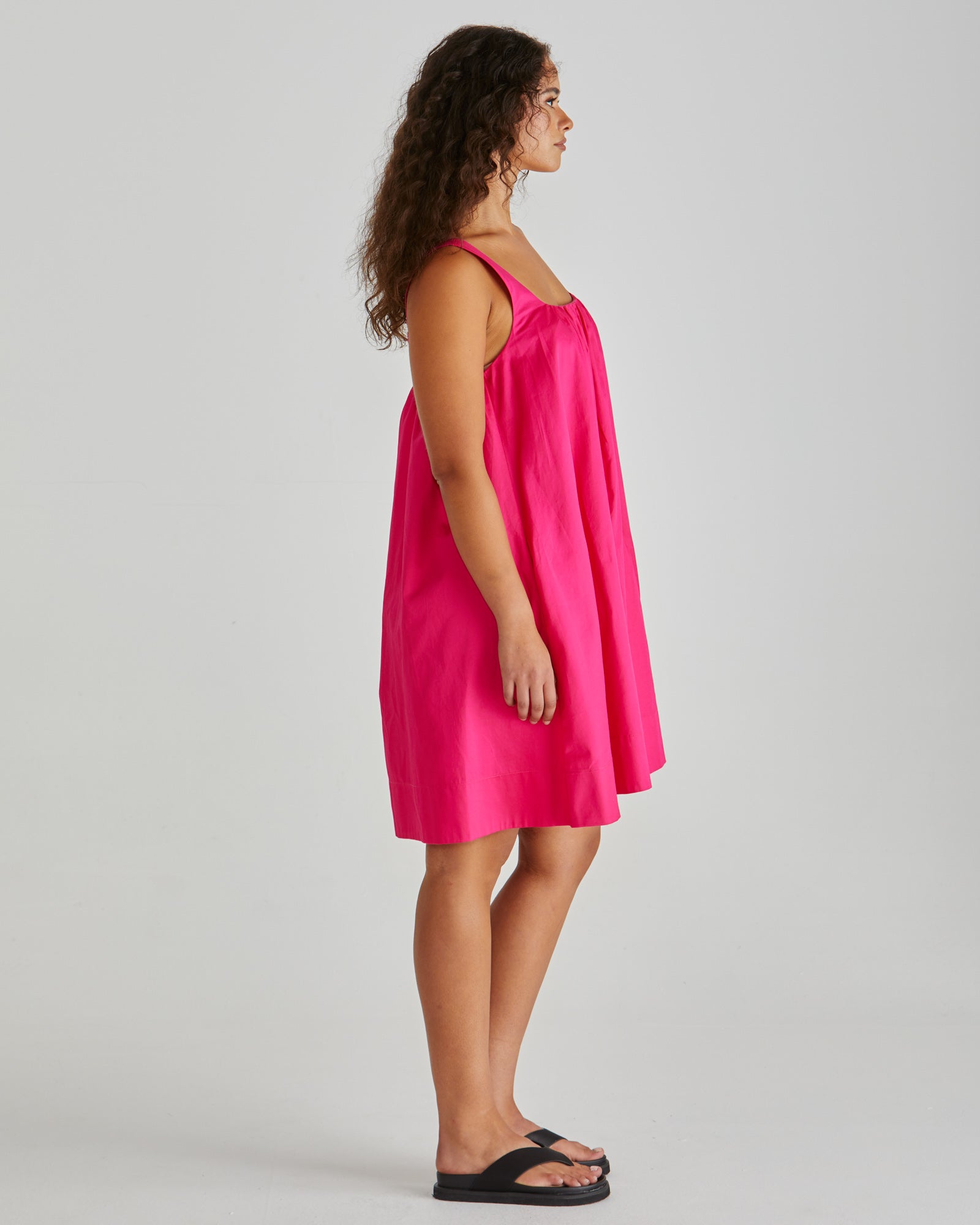 SASS Ellis Mini Dress in hot pink with scalloped wide hem and side pockets. Side view with wide straps. Available at Loloma Living.