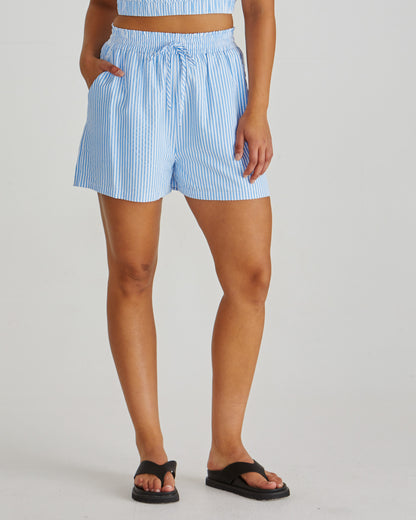 Close up of Lady wearing the SASS Alani Short in blue white stripe seersucker with elastic waist, drawcord and side pockets. Available at Loloma Living Tamborine Mountain - stockist of SASS and Betty Basics.

