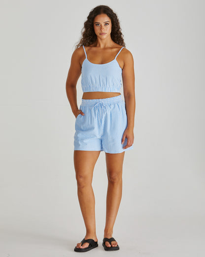 Lady wearing the SASS Alani Short in blue white stripe seersucker with elastic waist, drawcord and side pockets. Available at Loloma Living Tamborine Mountain - stockist of SASS and Betty Basics.

