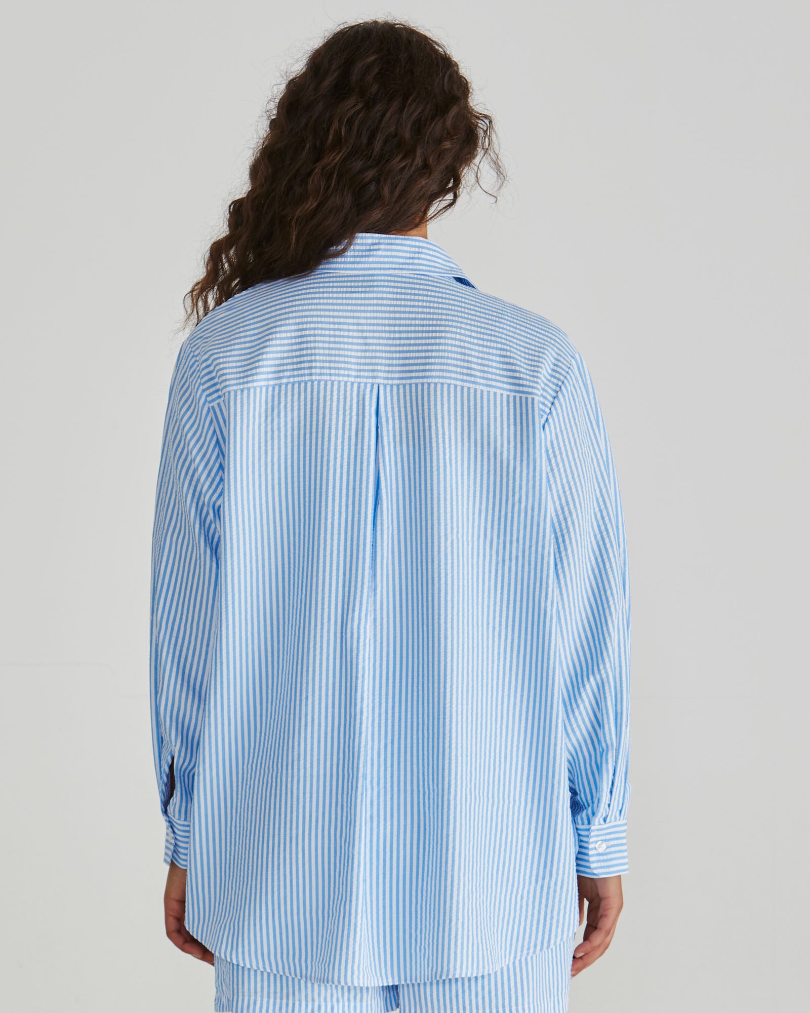 Back view of Lady wearing the SASS Alani Shirt in Blue White Stripe seersucker with concealed placket and dropped shoulder. Available at Loloma Living, Tamborine Mountain - stockist of SASS and Betty Basics.