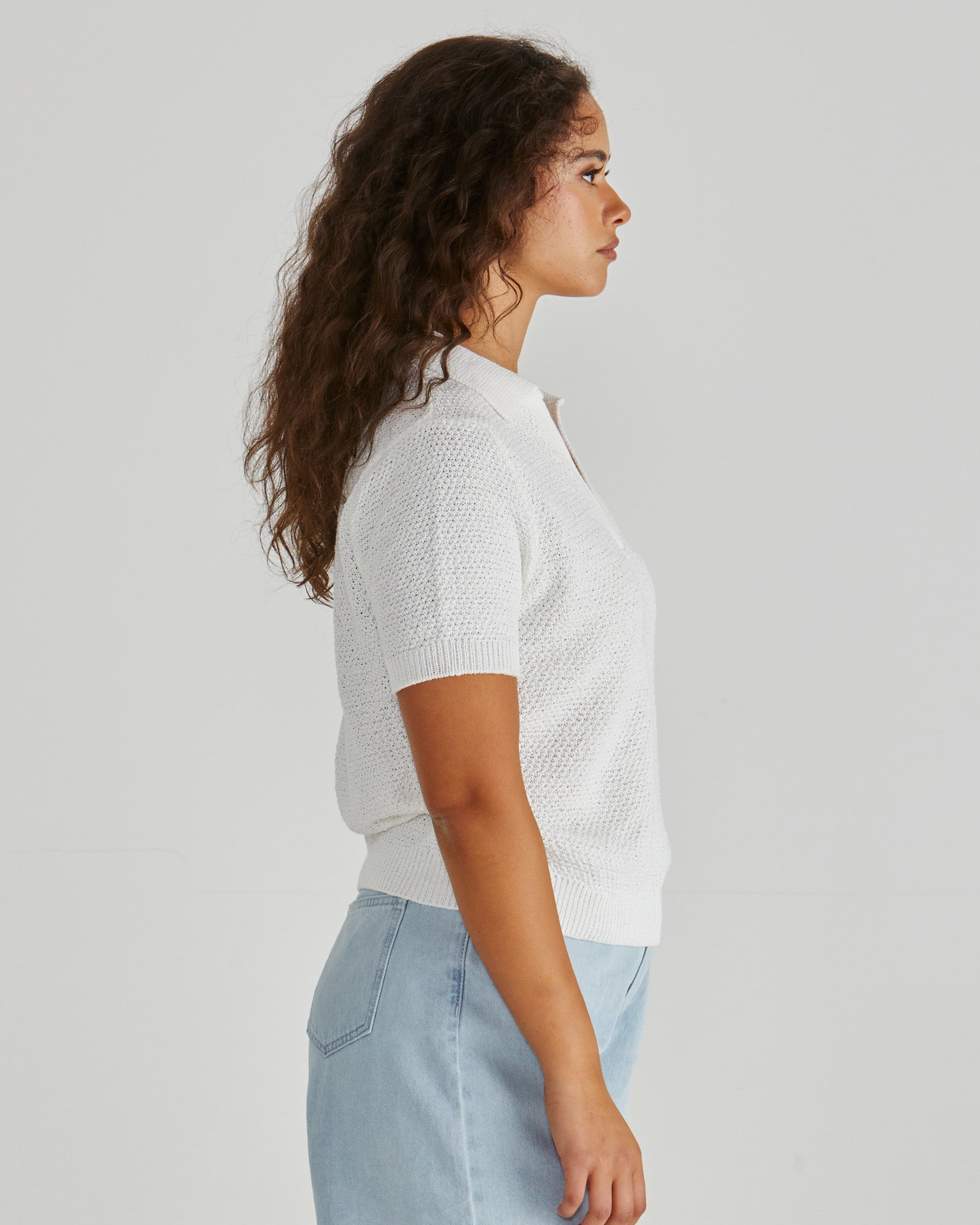 Side view of Lady wearing the SASS Aubrie Knit Polo in White.  Giving vintage sporty style. Elegant knit top. Available at Loloma Living in Tamborine Mountain- stockist of SASS and Betty Basics.