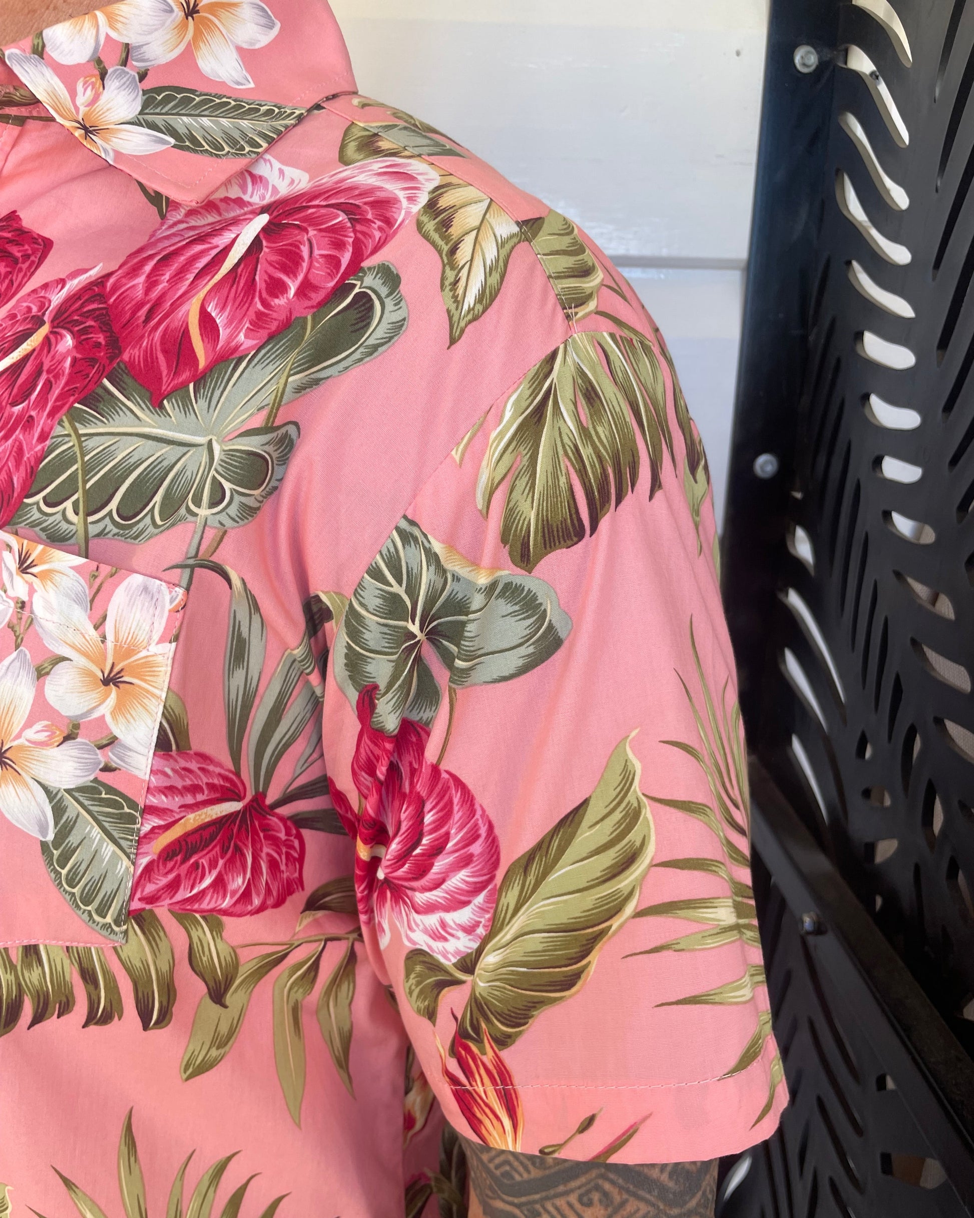 Man wearing island shirt pink tropical print showing a close up of the sleeve and collar. Available at Loloma Living Tamborine Mountain.