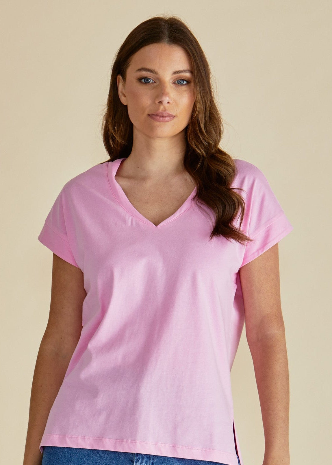Woman wearing a pink t-shirt and blue jeans against a beige background betty basics pink tshirt stockist Loloma Living Tamborine Mountain