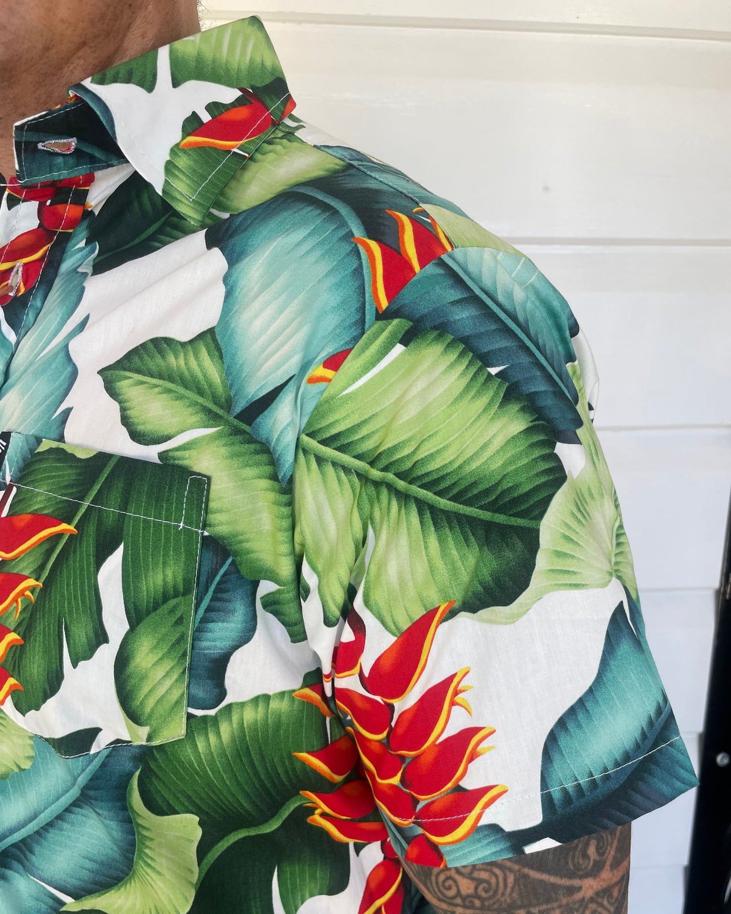 man wearing island shirt bula shirt showing a close up of the sleeve and collar in a tropical print. Available at Loloma Living Tamborine Mountain.